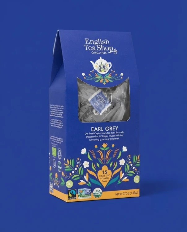 Organiczna herbata czarna z bergamotką w piramidkach English Tea Shop — opakowanie na tle w kolorze produktu