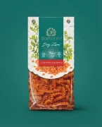 Dary Ziemi Makaron z czerwonej soczewicy - świderki 250g Bartolini — opakowanie na tle w kolorze produktu